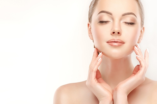 「素肌美を意識してフェイスラインに触れる女性のスキンケアイメージ｜美肌・保湿・毛穴・エイジングケアなどの美容効果を連想させる美しい横顔」