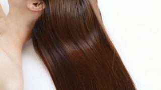 「髪に潤いを与えるヘアケアアイテムを使う女性｜自宅でサロン級の仕上がりに」