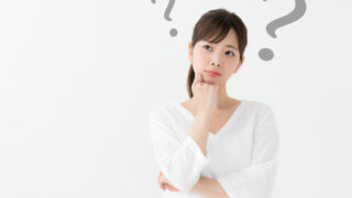 「悩んでいる女性が疑問を浮かべて考えている様子のイメージ。スキンケア選び・美容商品の比較・化粧品選択の迷いを表現」