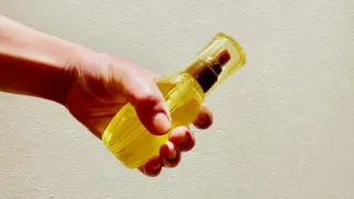 洗い流さないトリートメントを手に持つ男性が自信をつけている画像