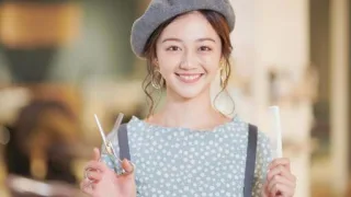 美容室で笑顔の女性美容師がハサミとコームを持っている写真。シャンプー解析やプロのヘアケア評価に関連するイメージ