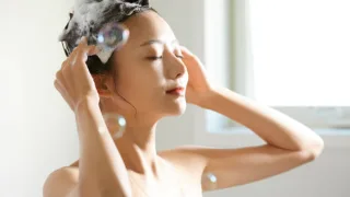 泡立てたシャンプーで髪と頭皮を丁寧に洗う女性。シャンプー解析やヘアケア、頭皮ケアに関連する記事イメージ