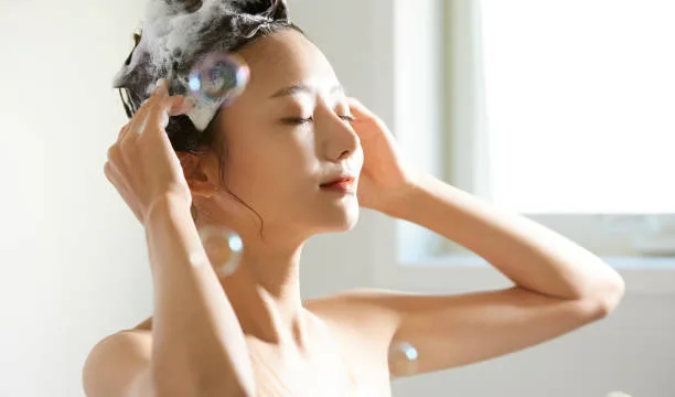 泡立てたシャンプーで髪と頭皮を丁寧に洗う女性。シャンプー解析やヘアケア、頭皮ケアに関連する記事イメージ