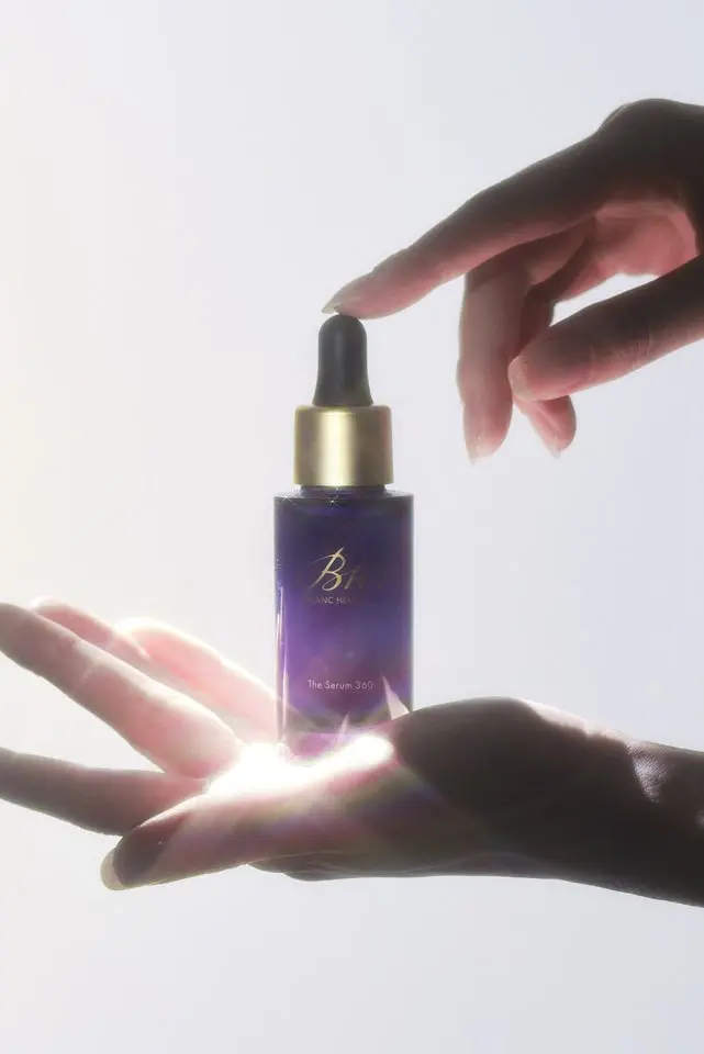 BLANC HEMOUR The Serum 360のボトル＆スポイト製品写真｜手のひらの上で光が差すディスプレイショット。